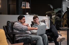 Two team members collaborating on a laptop